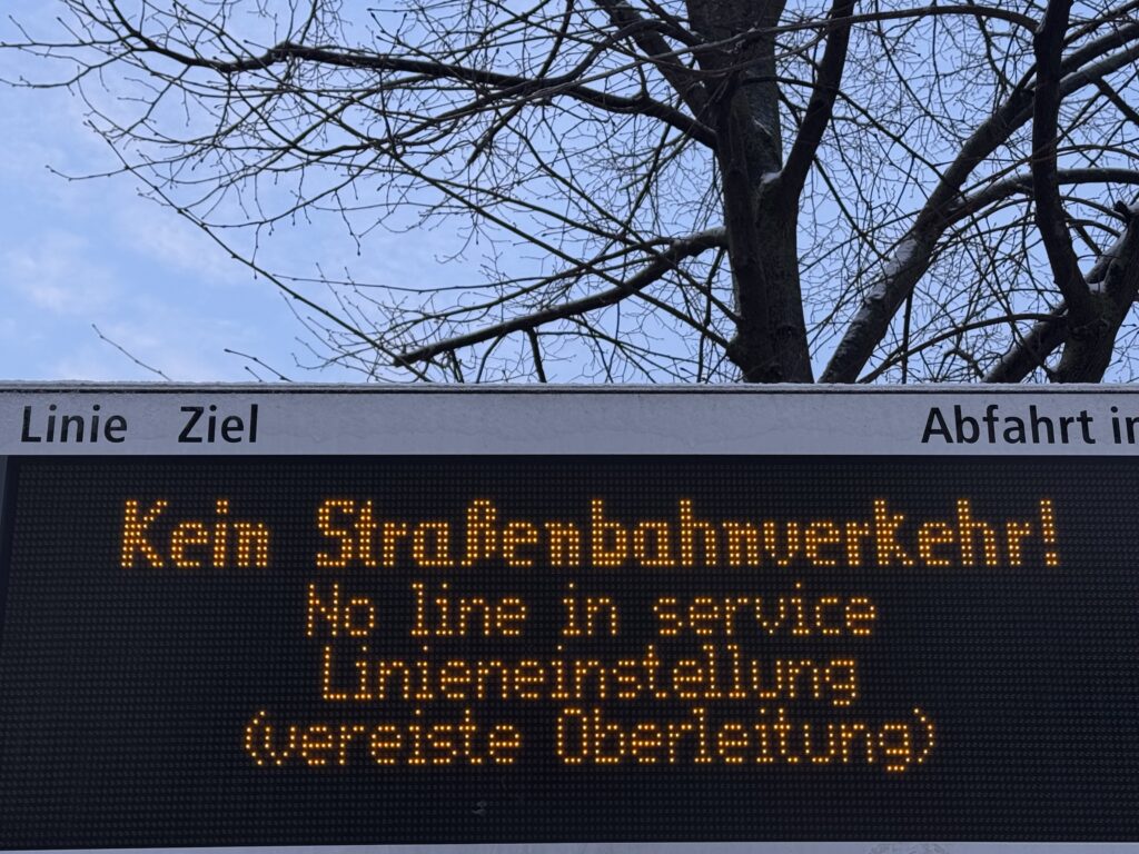 Eine elektronische Anzeigetafel zeigt, dass es keinen Straßenbahnverkehr gibt, da die Oberleitung vereist ist.